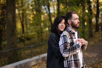 Fototapeta premium Cute couple hugging in autumn park. Space for text