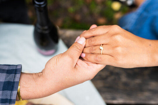Close up of engaged couple holding hands with ring during romantic autumn proposal at Lake Bled Slovenia