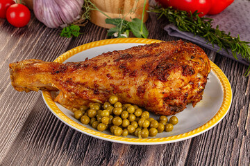 Baked turkey drumstick served green peas