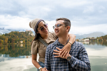 young couple celebrating romantic marriage proposal by lake bled surrounded by autumn scenery in slovenia