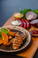 Grilled chicken with seasoned potato wedges and assorted sauces