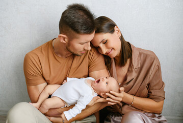 Loving Parents Holding Newborn Baby Together
