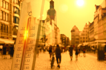 Thermometer showing high temperature, double exposure with city street during hot day
