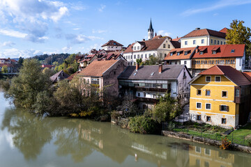 engaged couple enjoying autumn proposal at lake bled slovenia with colorful village and natural scenery
