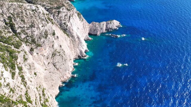Aerial drone cinematic video of white beach consisting of volcanic caves and white steep hill near famous shipwreck cove a wonder of nature, Zakinthos island, Ionian, Greece