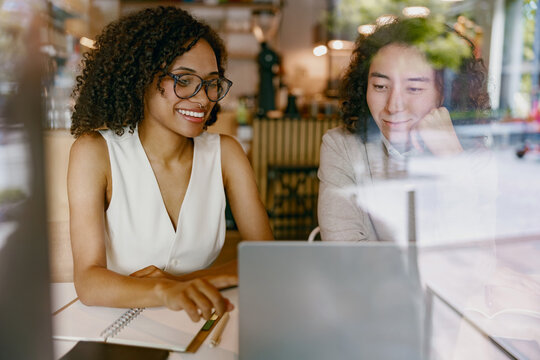 eight professionals brainstorming, group of coworkers collaborating with laptops and notes outdoors