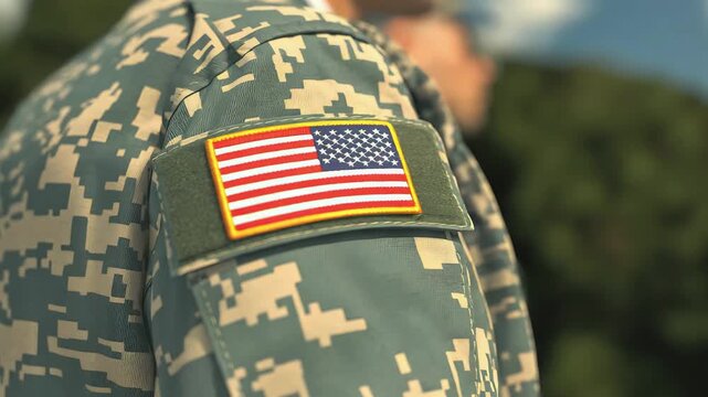Close‑Up of U.S. Military Uniform Sleeve with American Flag Patch in Camouflage Pattern