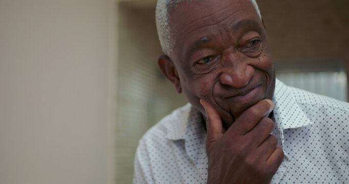 Elderly African American man resting chin on hand, showing concern with a pensive and introspective demeanor, reflecting deeply on life choices in a thoughtful moment indoors