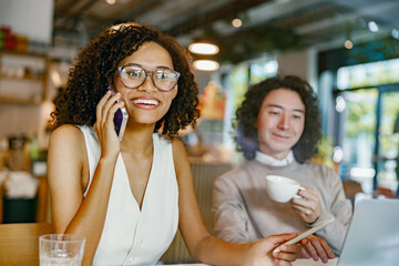 casual business environment with woman confidently speaking on her mobile phone in coffee shop