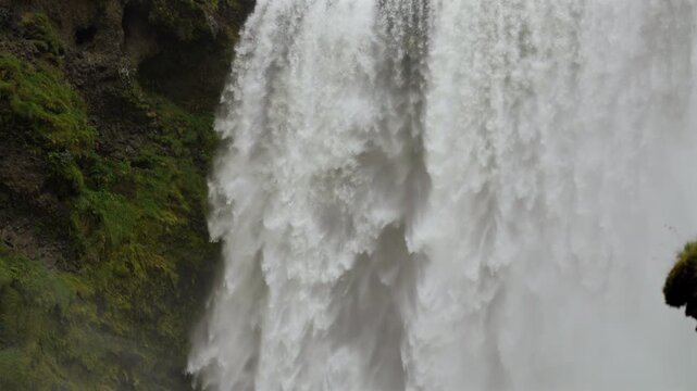 Powerful Waterfall Flowing over Rocky Cliff