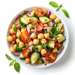 A bowl filled with chickpea salad featuring tomatoes cucumbers and red onions viewed above