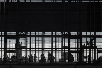 Schwarz weiß Aufnahme von Silhouetten von Personen in einem Gebäude aus Glas