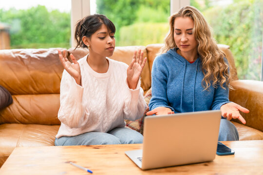 Friends discussing online during a cozy evening at home while working on a laptop