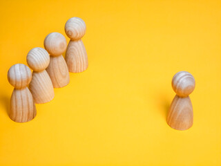 Leadership and individuality concept with wooden figures on yellow background