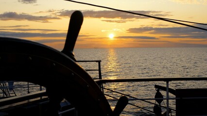seascape and silhouette of a ship's wheel
