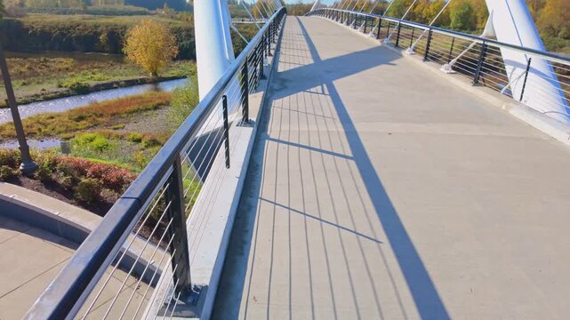 A picturesque view of a pedestrian bridge or scenic viewpoint within Salem's Riverfront City Park, surrounded by vibrant and colorful fall foliage and reflecting in the Willamette River.