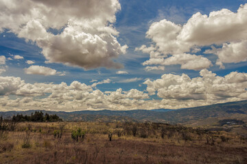 Panoramic view of the landscape of the La Candelaria desert, with dense bright clouds at the horizon, in the eastern Andean mountains of central Colombia, near the town of Raquira.