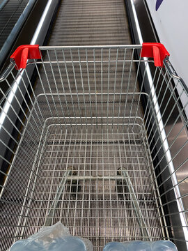 Fragment of shopping cart on travelator or moving walkway, top view. Metal cart trolley. People mover.