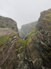 Fototapeta premium Majestic cliffs rise through misty narrow gorge.
