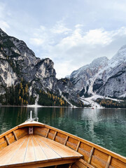 Wooden boat glides across crystal alpine lake.