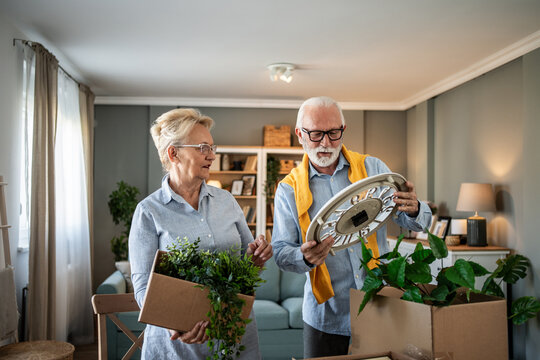 Senior couple unpacking items while moving into new home