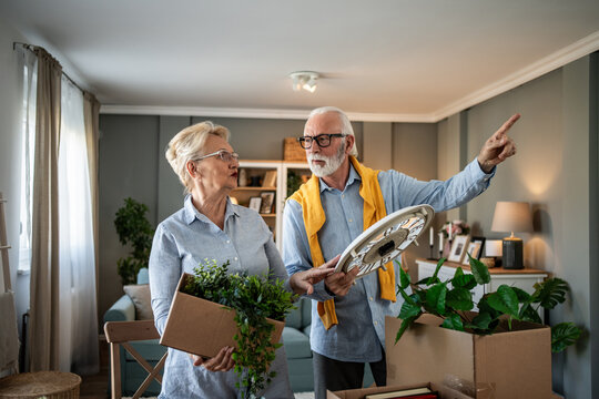 Senior couple moving to new home unpacking boxes