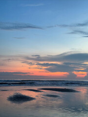 Soft hues paint waves beneath fading daylight.