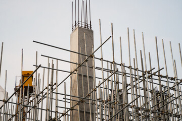 Vertical concrete column and scaffolding structure on industrial construction site outdoors