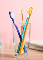 Natural bamboo and plastic toothbrushes on the table.. Vertical photo format