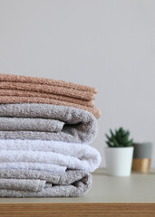 a stack of fresh towels on the table.. Vertical photo format