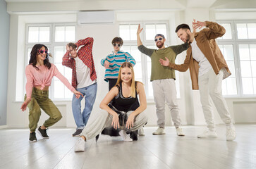 Dancing modern group of young people posing confidently, energetically, diverse team standing...