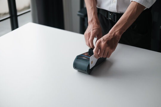 employee swipes a credit card at EDC to complete a secure payment