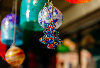 Colorful glass christmas ornament hanging in sunlit market