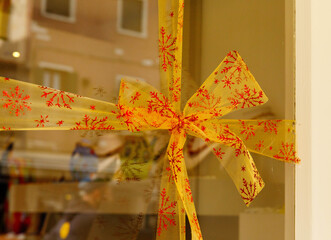 Festive yellow ribbon with red snowflakes on display window