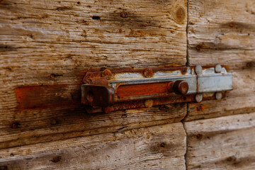 Rustic wooden door with weathered metal bolt close-up