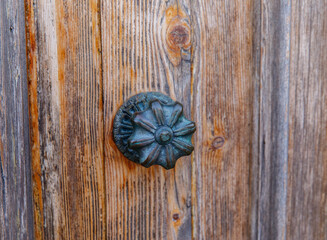 Rustic wooden door with vintage metal knob in weathered wood texture
