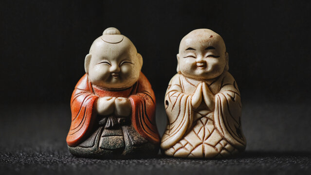 Two ivory-style netsuke figurines with joyful expressions , art catalogs, auction visuals, Japanese culture promotions, museum publications, educational materials, cultural branding 