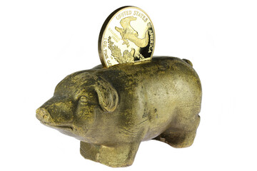 antique piggy bank with 1 ounce American gold eagle bullion coin isolated on white background