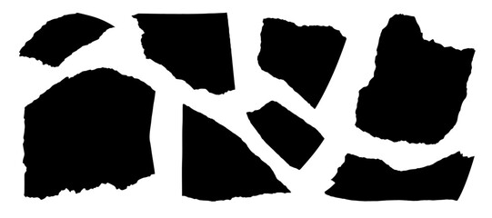 black paper scraps scattered on a white background surface view.