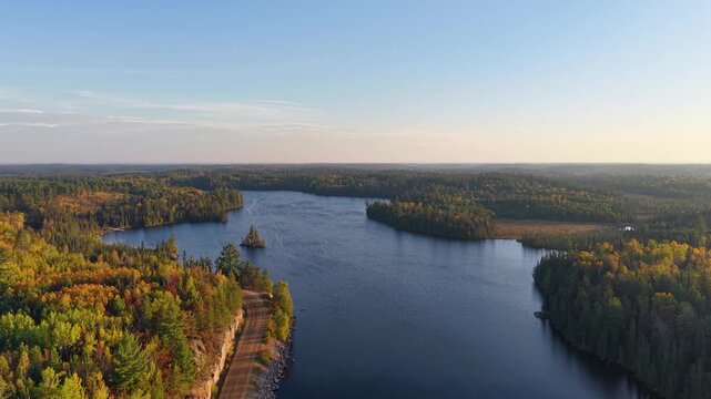 MINNESOTA - 10.31.2025 - Excellent aerial footage moving over a lake in the midst of an autumnal Minnesota forest.
