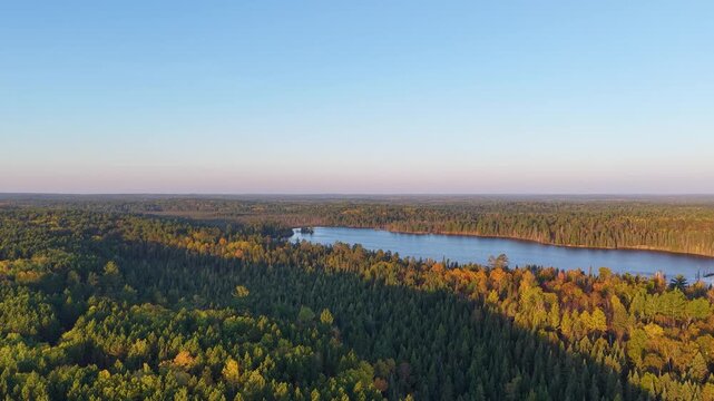 MINNESOTA - 10.31.2025 - Stunning aerial footage approaching a lake in the midst of a vast autumnal Minnesota forest.