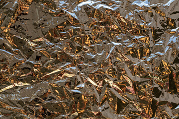 Crumpled metallic foil texture with copper and silver reflections for abstract background