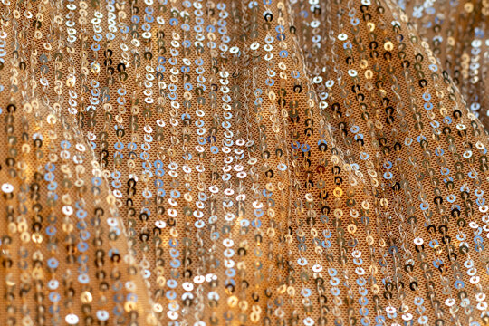 Gold sequin fabric backdrop with shimmering sparkle for fashion, party, and glamour shoots