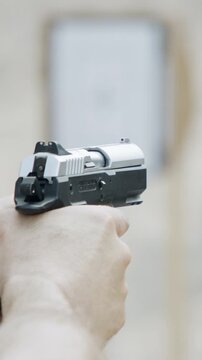 Slow motion of a hand gun firing in a firing range with cartridge flying away