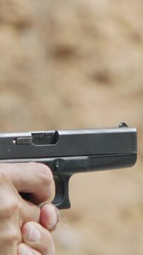 Slow motion of a hand gun firing in a firing range with cartridge flying away