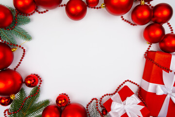 Top view Christmas border with red ornaments fir branches and gift boxes on white background minimal festive layout with empty space for holiday mockup card banner or New Year greeting template