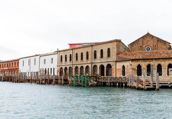 Murano, Italy - November 21, 2024: Scenic view of historic Murano island buildings along the waterfront, showcasing Venetian architecture and tranquil waters with copy space