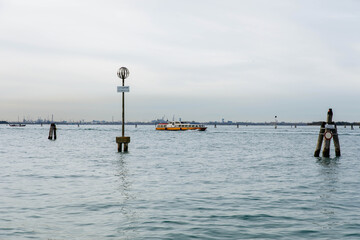 Murano, Italy - November 21, 2024: Scenic view of Murano Island with a boat navigating through calm waters, showcasing iconic landmarks and serene atmosphere for travel enthusiasts