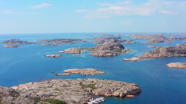Sweden west coast aerial drone shot. Swedish coastline with small rocky islands smooth cliffs and boats on a sunny day. Clean blue ocean landscape sunny summer day