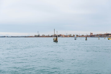 Murano, Italy - November 21, 2024: Scenic view of Murano Island with calm waters and distant buildings, showcasing the tranquil beauty of this famous Venetian destination